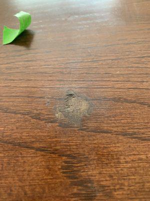 Dining room table leaf where they gashed it and just used a marker to color it in and nit filling the hole.