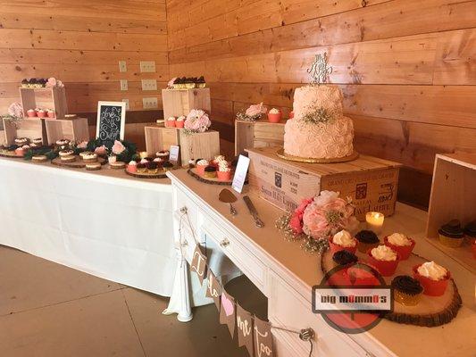 2 tier blush wedding cake and dessert display. We provide the stands and displays when you add dessert to your catered meal.