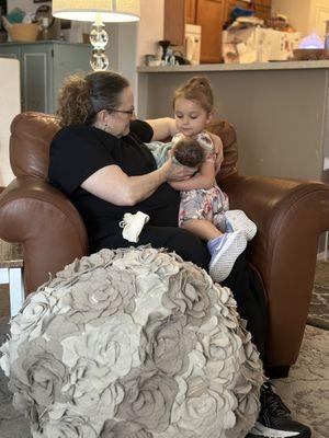 Connie helping my daughter hold her new baby brother.