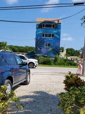 Directly across the street from the tall building with the underwater mural painted on it.