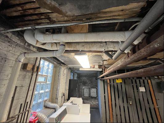 Laundry room ceiling with water-damaged wood beams and holes in ceiling.