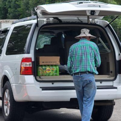 Volunteers load food into vehicles during a Monday distribution in Bronson.