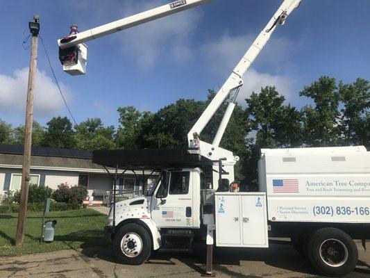 Trimming trees off a customer's electric line