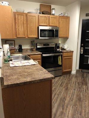 Kitchen with dishwasher, ceramic stove top and range, microwave and garbage disposal with new flooring and outlet USB chargers.