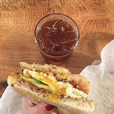 The Noxi with a fried egg, chipotle aioli, black beans, avocado,cotija, radish & cilantro on a torta