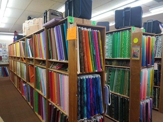 Fabric store in Glendale, AZ with sewing machine bags or trolleys on top shelves. Great prices always.