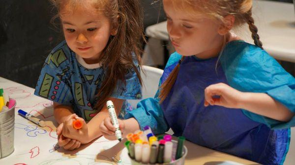 Kids working carefully on their artwork in a group class.