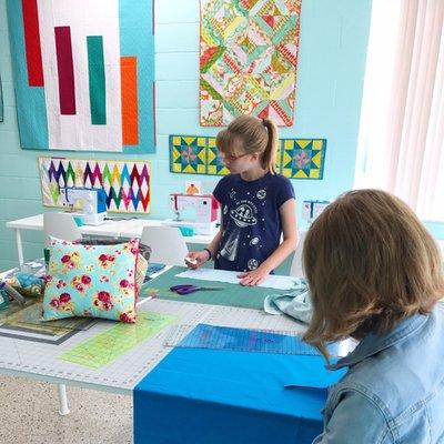 Busy students learning how to make a pillow cover in our beginner sewing class.