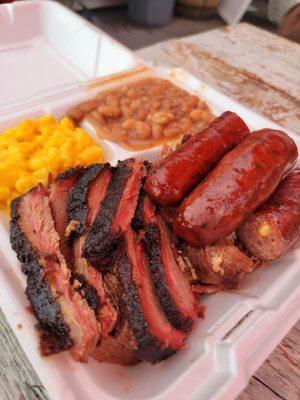 3 meat plate with beans and macaroni and cheese.