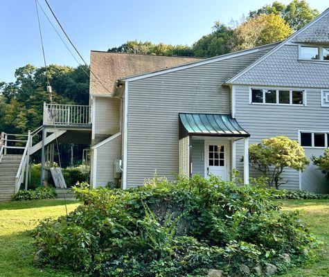 Front of carriage house with "garbage" on porch.