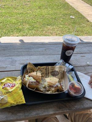 The Grinder sandwich with chips, fruit cup, pickle, and cookie