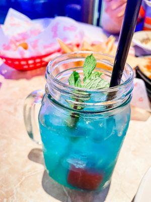 Blue ocean! It has: Blue curaçao liqueur, DeKuyper® Peachtree Schnapps, splash of Sprite®, & a cranberry cube. It's a must have!!