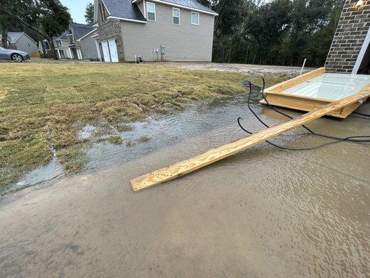 Flooded driveway, uneven yard.