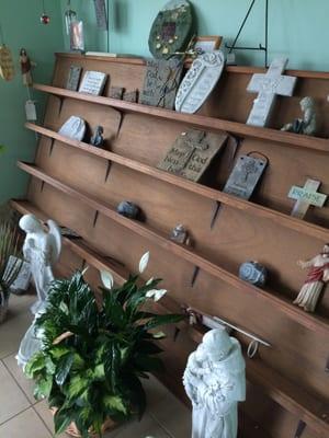 Beautiful array of different and  varied cement outdoor plaques adorn the shelves of Villager Flowers on W. Broad St.