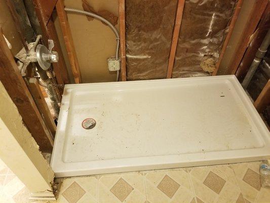 Install shower pan in new construction bathroom