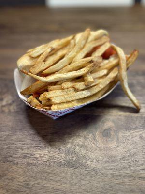 Steak sandwich covered by a bedding of thick cut fries