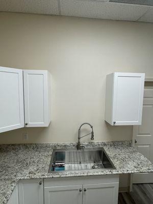 Office kitchenette upgrade. Cabinets installed and painted; deep basin sink with pull-out spray head faucet.