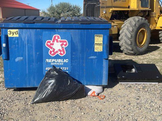 Dumpster dropped on bags of garbage by driver