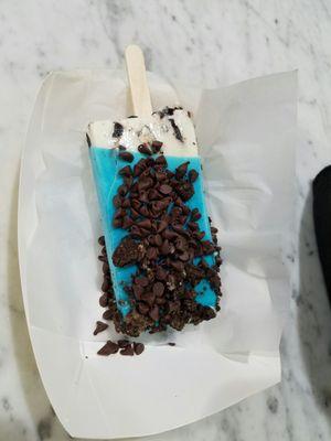 Cookie monster pop w extra choco chips.  A cookies and cream pop, dipped in blueberry with cookie crumble. (Extra chocolate chips)