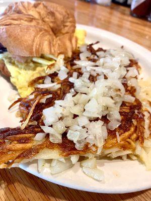 Bacon, egg & pepper jack cheese sandwich on croissant w/shredded hash browns & onion