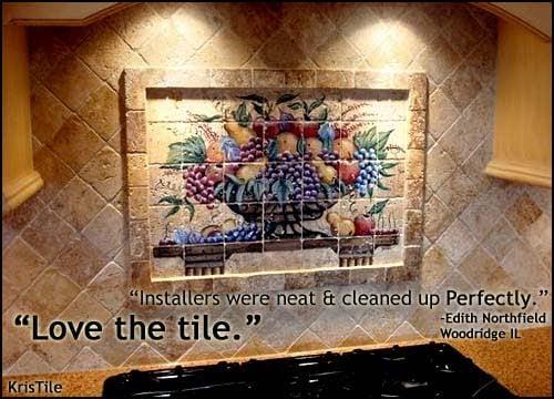 Custom painted tiles delicately installed within the picture frame of this backsplash.