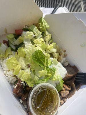 My rice bowl and a side of the lemon vinaigrette did half chicken half gyro meat add d feta lettuce some hummus broccoli and potatoes