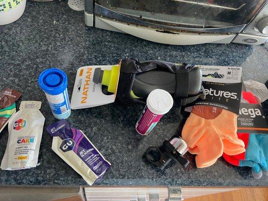 Running spread: gels and pills and water bottle and running socks and bike bell