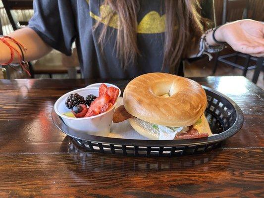 Eggs Benedict on a fresh toasted bagel with hollandaise sauce and fruit