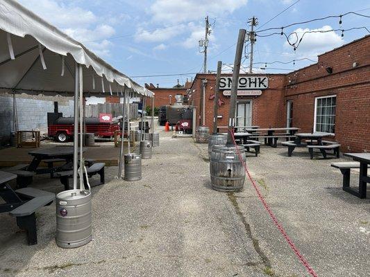 Entrance is to the left of the sign around the smoker. Worth the adventure!!