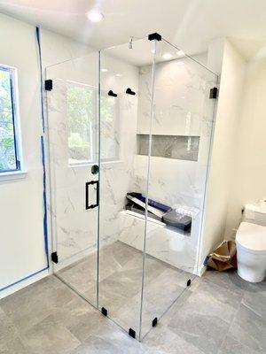 Frameless 90 degree shower enclosure on a Curbless shower.