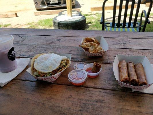 Two tacos (pork and chicken), with a duck egg on top of one of the tacos; chicken skin chicharones, four lumpia, and ube horchata!