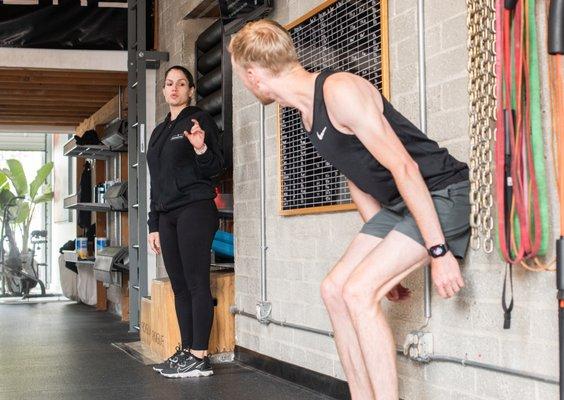 Coach Sanam explaining to one of our athletes how to access a proper deadlift without hurting their low back.