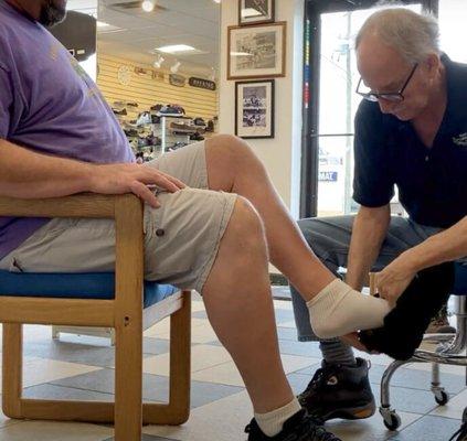 Frank helping to fit a customers shoes.