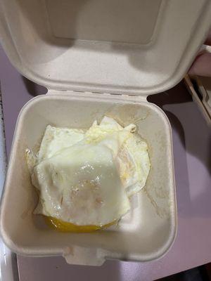 Overcooked eggs dumped in a cardboard container to be scraped out