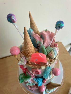 Top of cake included ice cream cones, cotton candy, lollipops and marshmallows