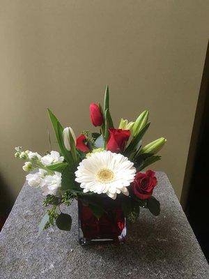 Red and white mixed flowers in red cube vase