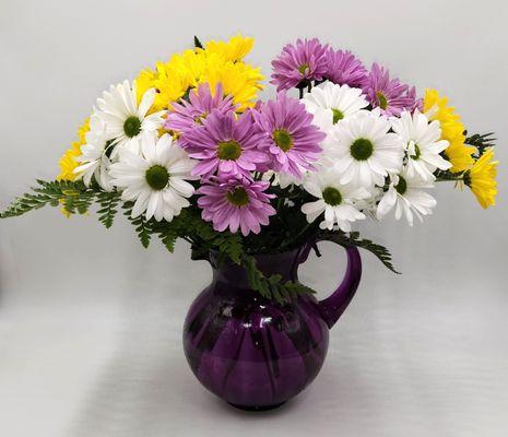 A pitcher full of beautiful daisies