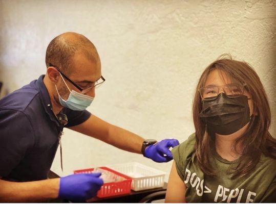 Pharmacist Mark finishing up Emiliano vaccine