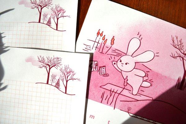 Illustrated calendar page on cardstock and letter sheets on writing paper