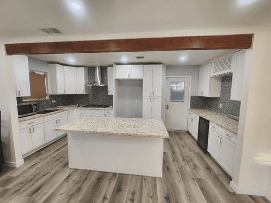 Step into this stunning open-concept kitchen featuring beautiful exposed wood beams and a spacious island