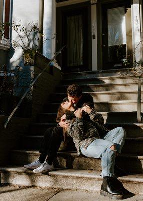 Couple sitting on the front porch steps in the city