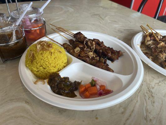 Pork skewers, chicken skewer, yellow rice, and free pickle/and spicy paste (not sure of the name).