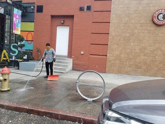 Local businessman cleaning up his space after they dumped food.