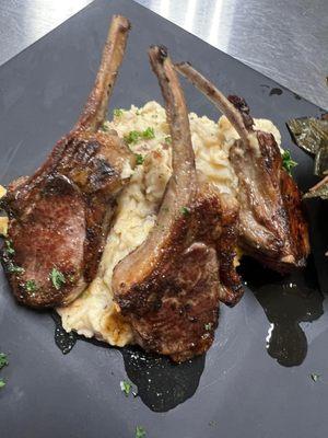 Lamb chops over red roasted potatoes.