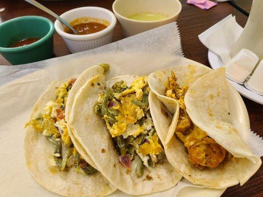 Two nopales and egg tacos, one chorizo and egg taco, and three salsas.  Flour tortillas.