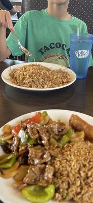 Plain fried rice on top and pepper steak and onions combo on bottom.