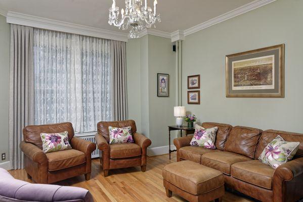 A Combination of sheers, room-darkening shades beneath, and tailored side panels in a Capital Hill townhouse. Custom pillows unify the room.