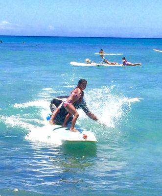 My daughter surfing with Paulo.