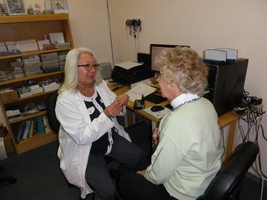 Pam, our audiologist, explains the features of a patient's new hearing aids.