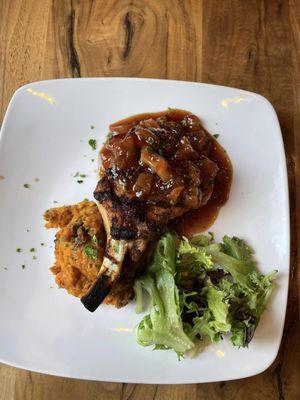 Peach Glazed Pork Chop! 10oz French style pork chop topped with sweet & spicy peach glaze. Served over sweet potato-pecan soufflé.